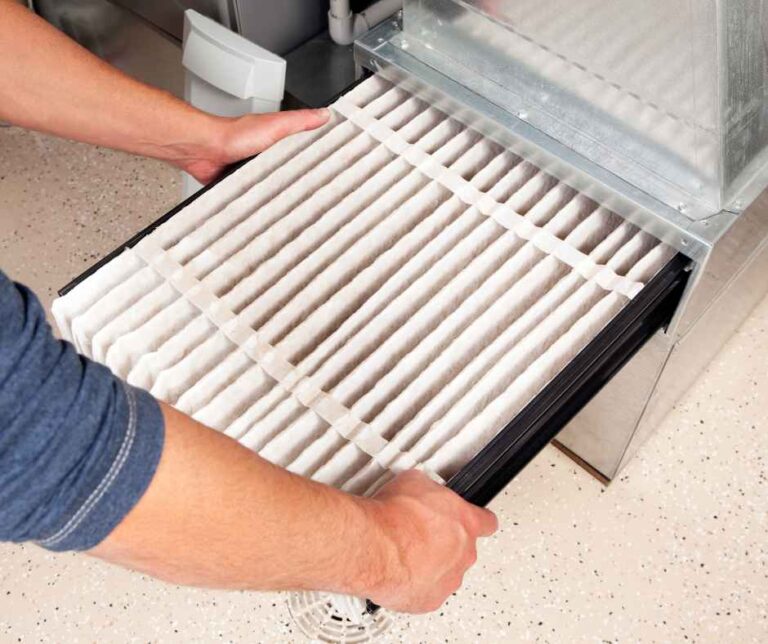 A person changing their furnace filter