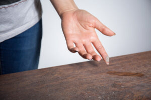 Dust on Table Near Woman's Hand