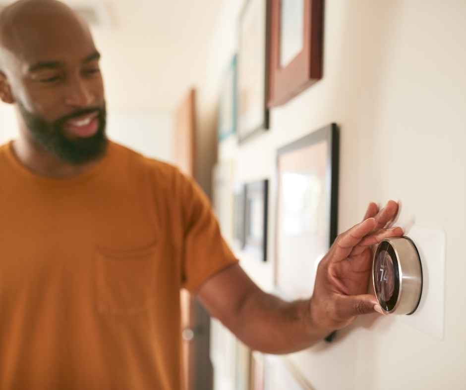 Turning the dial on a smart thermostat to adjust the temperature